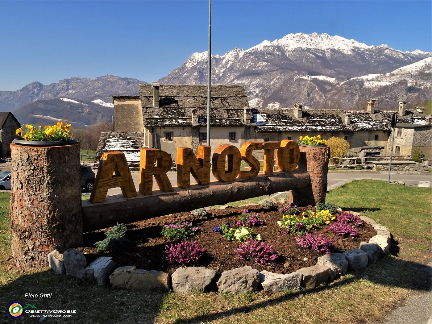01 Sciolta le neve sui tetti a piode del borgo di Arnosto, ancora ben imbiancato il Resegone.JPG